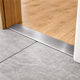 Anodised aluminium flat door threshold strip with self-adhesive backing for quick, drill-free installation.
