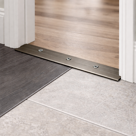 Usage of A08 35mm anodised aluminium flat threshold strip fitted in the centre of a door opening to join indoor and outdoor flooring.