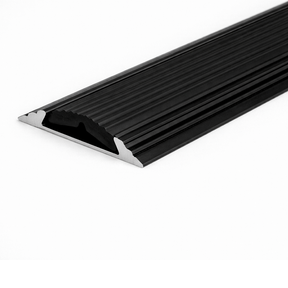 Black A10 anodised aluminium flat non-slip threshold strip installed between two floor surfaces for added safety.