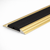 Golden A10 anodised aluminium flat non-slip threshold strip installed between two floor surfaces for added safety.